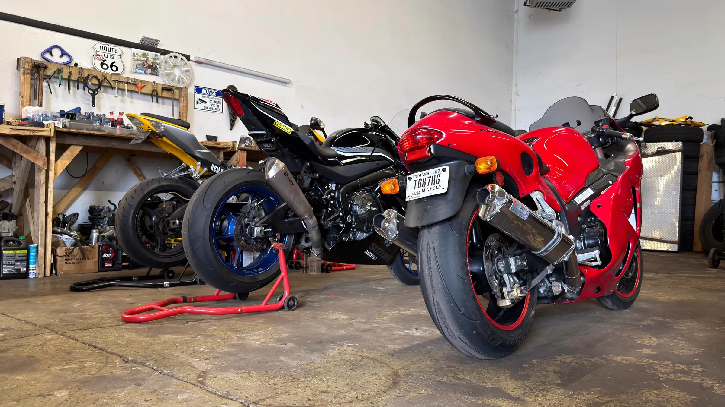 Suzuki and Yamaha sportbikes on paddock stands inside TT Sport Garage, Carol Stream