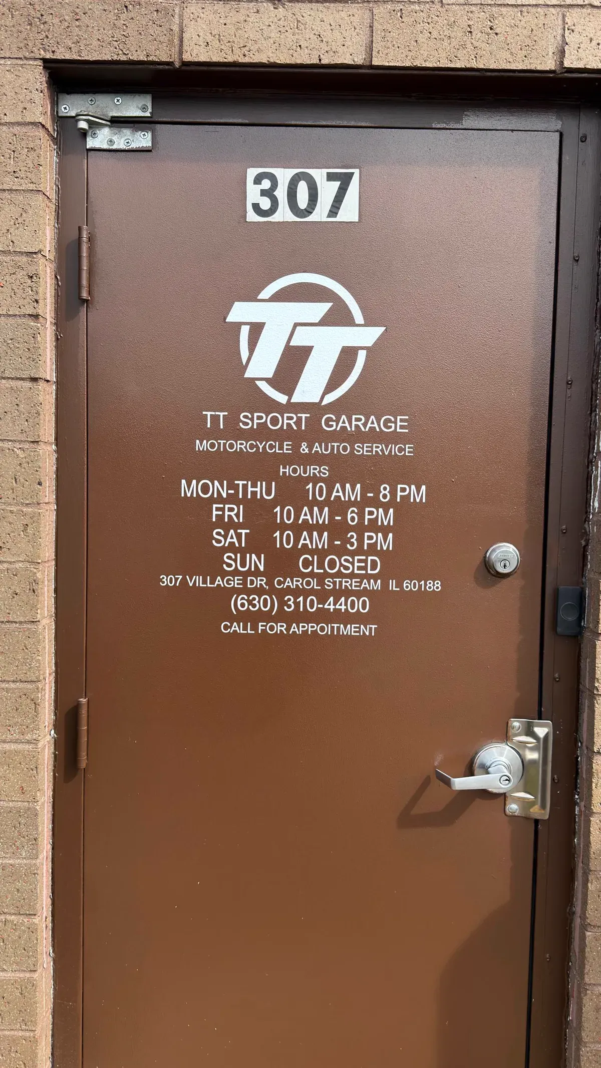 Door of TT Sport Garage at 307 Village Dr, Carol Stream, IL with hours and phone number